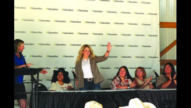 Britni Ross waves from the stage upon being named Dakotafest Woman Farmer of the Year Thursday. She helps run two ranches near Philip, S.D., using her background in financial management. Tri-State Neighbor photo by Janelle Atyeo
