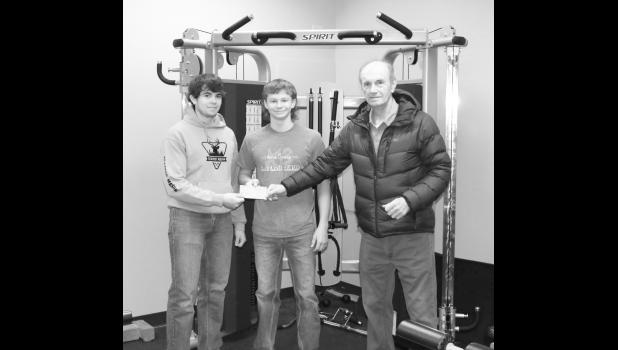 L-R; Tanner Willert and Mathew Birkeland graciously accept a check for the Community Weight Room from Jones County Community Foundation member Jim Butt. Courtesy photo