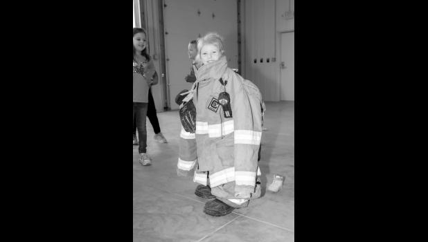 The kids got to try on the fire fighting gear. Baylor Buxcel is lookin’ sharp! Photo by Barb Hockenbary Photography