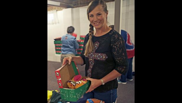 Lavonne Kinsley, head of the Operation Christmas Child program at Community Bible Church fills a shoe box with items in preparation to be sent out.