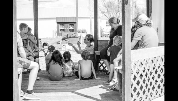 Jen Strait reads a children’s book at the gazebo during story time on Sunday. Photo by Barb Hockenbary Photography